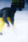 Phil McCausland cutting through the ice with a chainsaw.